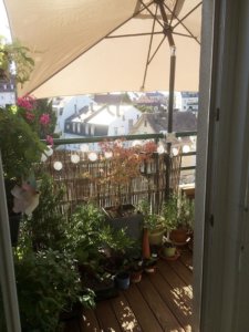 Un parasol installé sur un balcon